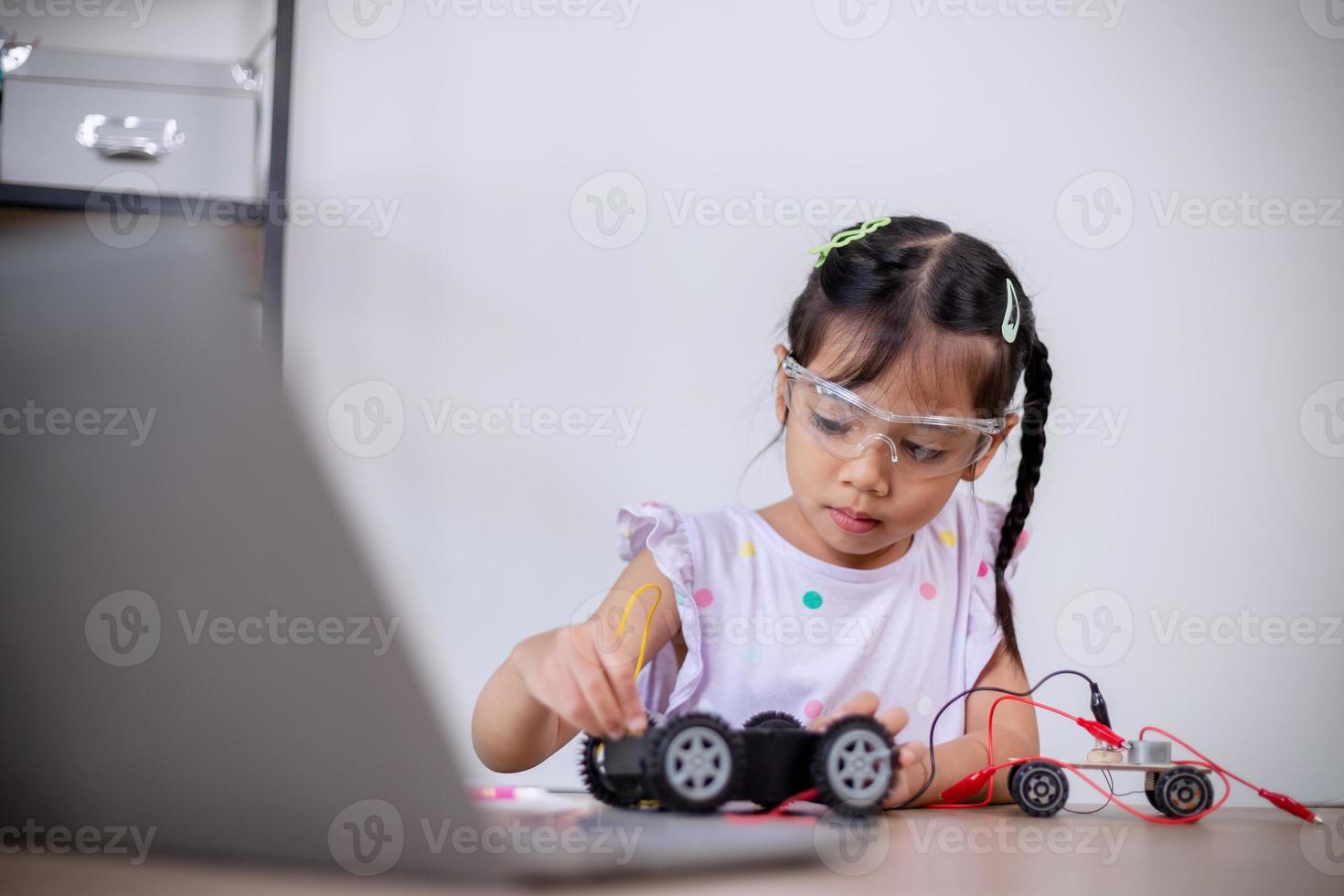 les étudiants asiatiques apprennent à la maison en codant des voitures robotisées et des câbles de carte électronique dans la tige, la vapeur, le code informatique de la technologie des sciences de l'ingénierie mathématique dans la robotique pour les concepts des enfants. photo