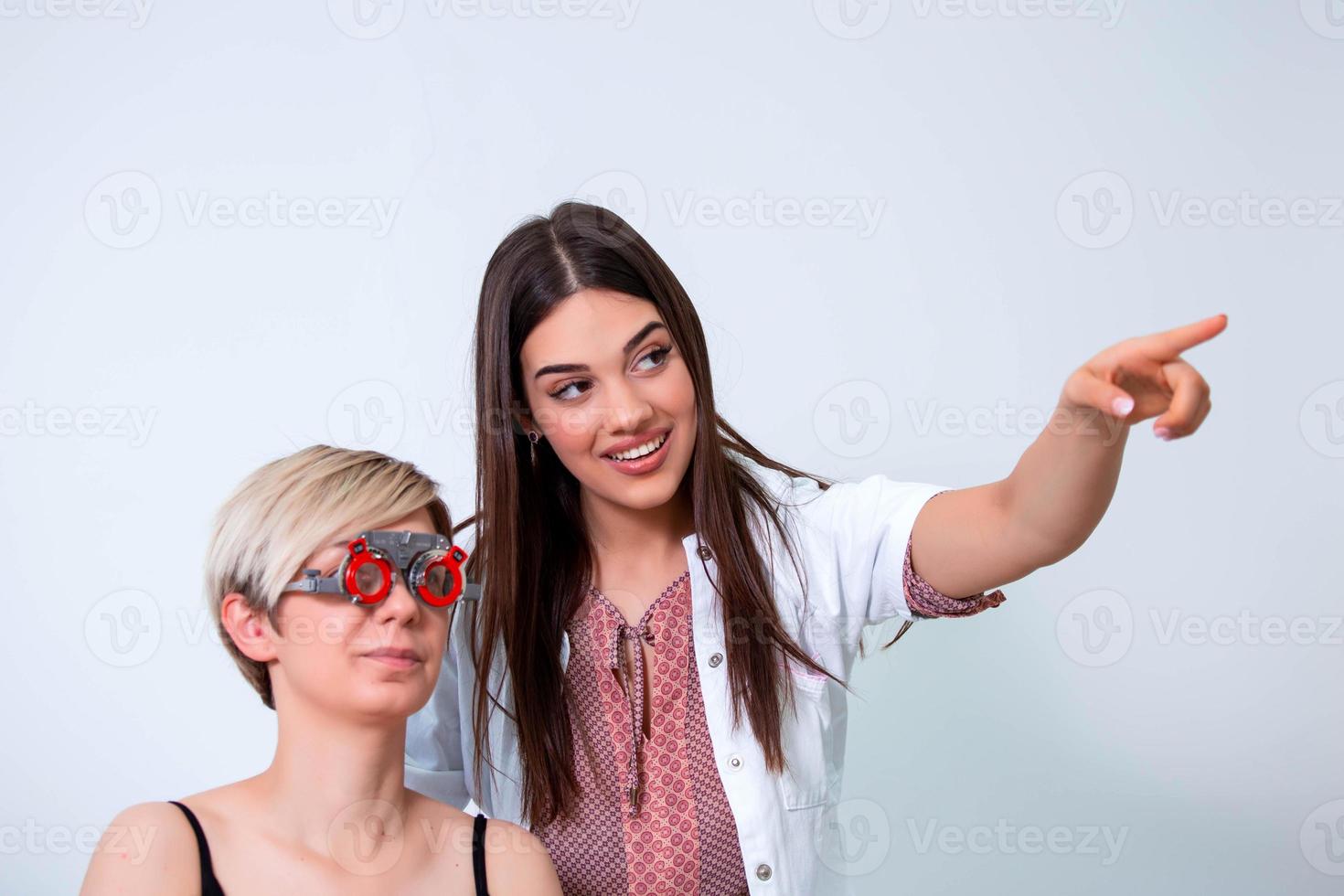 ophtalmologiste examinant une femme avec cadre d'essai d'optométriste. patiente pour vérifier la vision dans une clinique ophtalmologique photo