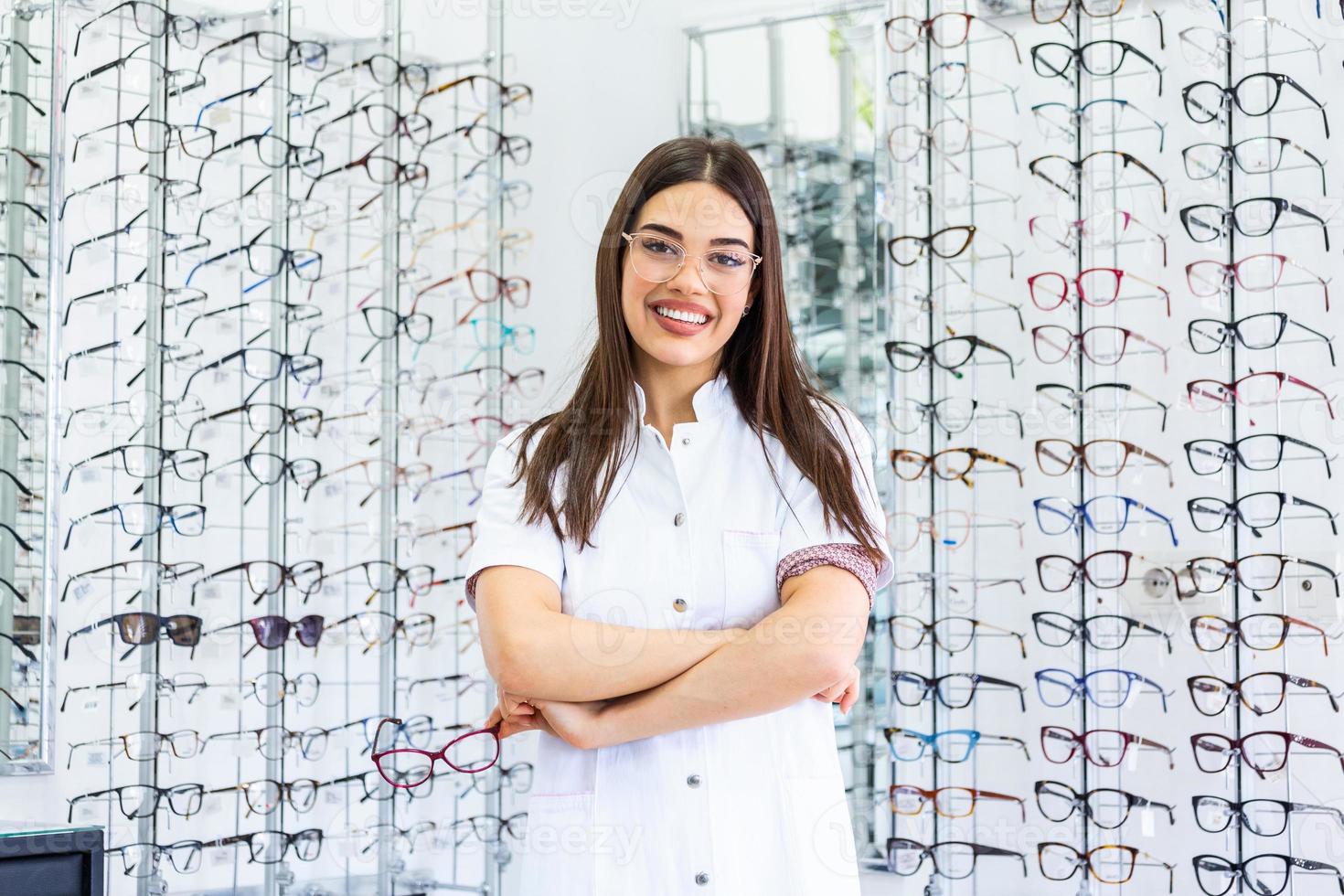 opticien vendant des lunettes à l'optique. opticien heureux vendant des lunettes et regardant la caméra en souriant. sympathique ophtalmologiste vendant des lunettes dans un magasin d'optique et regardant la caméra en souriant photo