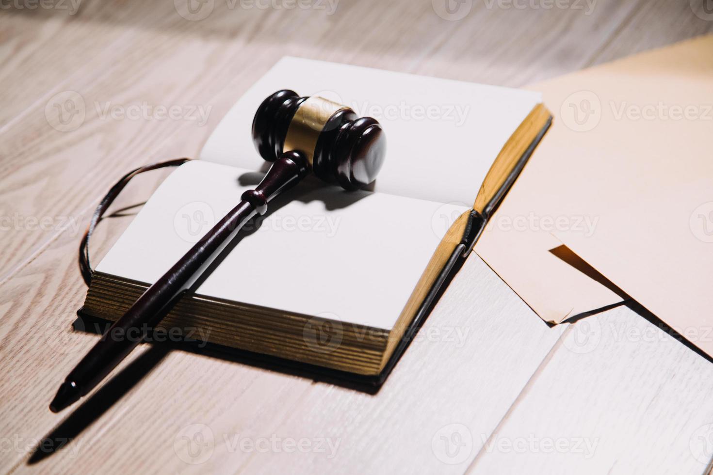 concept de justice et de droit. juge masculin dans une salle d'audience avec le marteau, travaillant avec, clavier d'ordinateur et d'accueil, lunettes, sur table à la lumière du matin photo