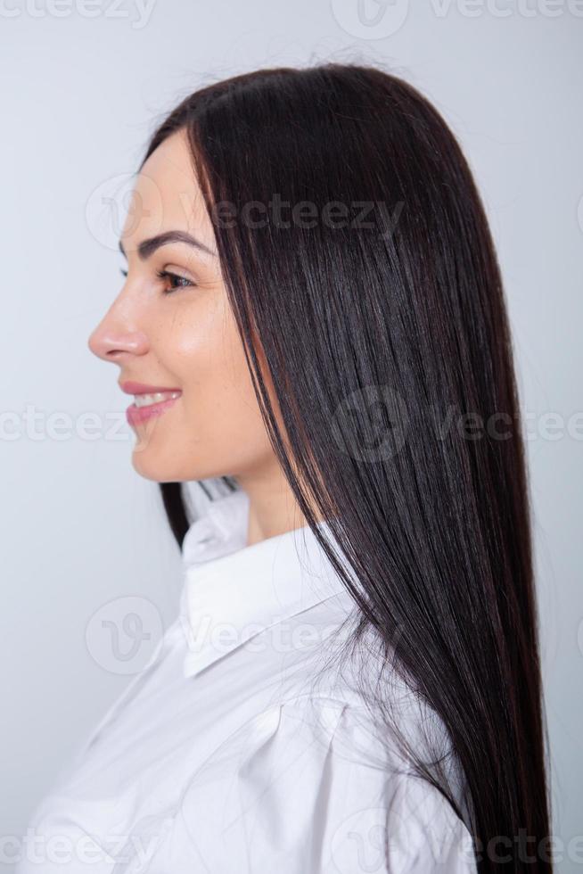 belle jeune femme aux longs cheveux noirs dans un salon de beauté. photo