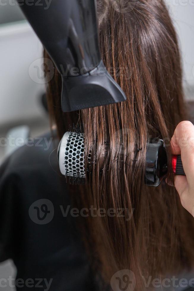 une chevelure brune droite et saine qui a subi la procédure de lissage des cheveux. cheveux bruns lisses, brillants et sains photo