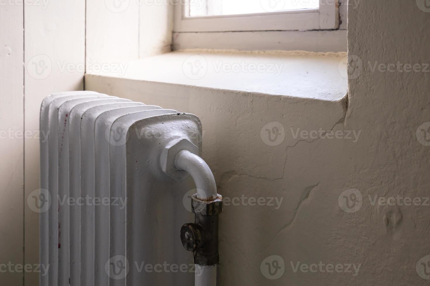 vieux radiateur avec une vanne qui éteint ou allume le chauffage. concept de crise et d'économie d'énergie, en raison de l'augmentation des coûts de chauffage. photo