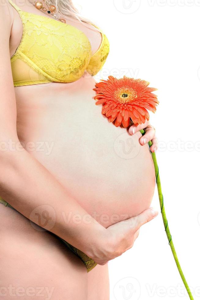 ventre d'une jeune femme enceinte avec fleur photo