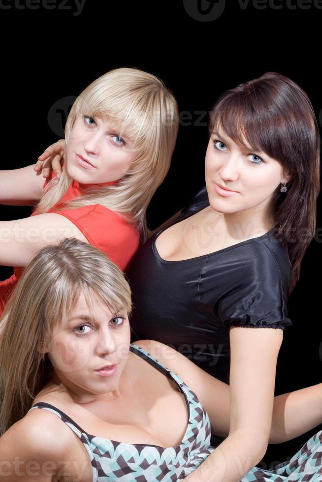 trois belles jeunes femmes. isolé sur noir photo