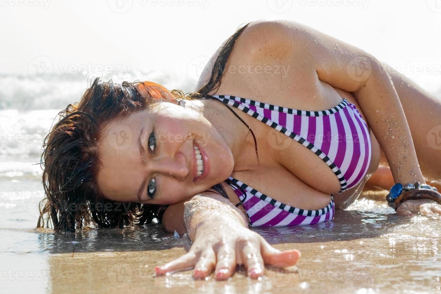 la jeune femme se trouve dans les vagues sur la côte de la mer photo