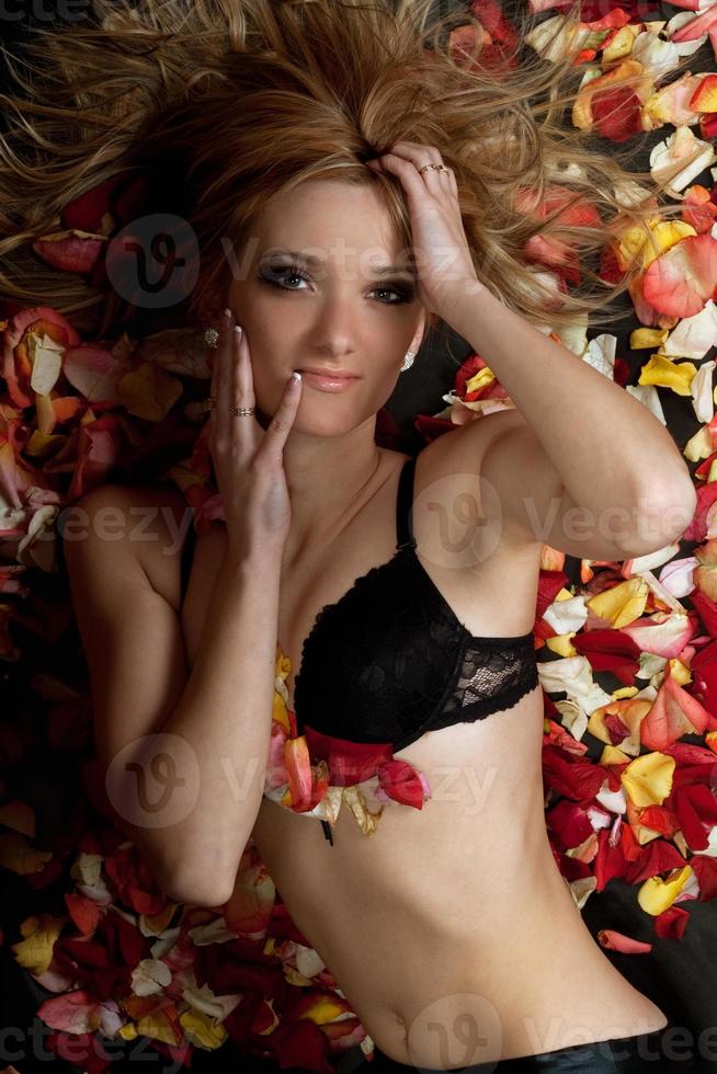 charmante blonde allongée dans des pétales de rose photo