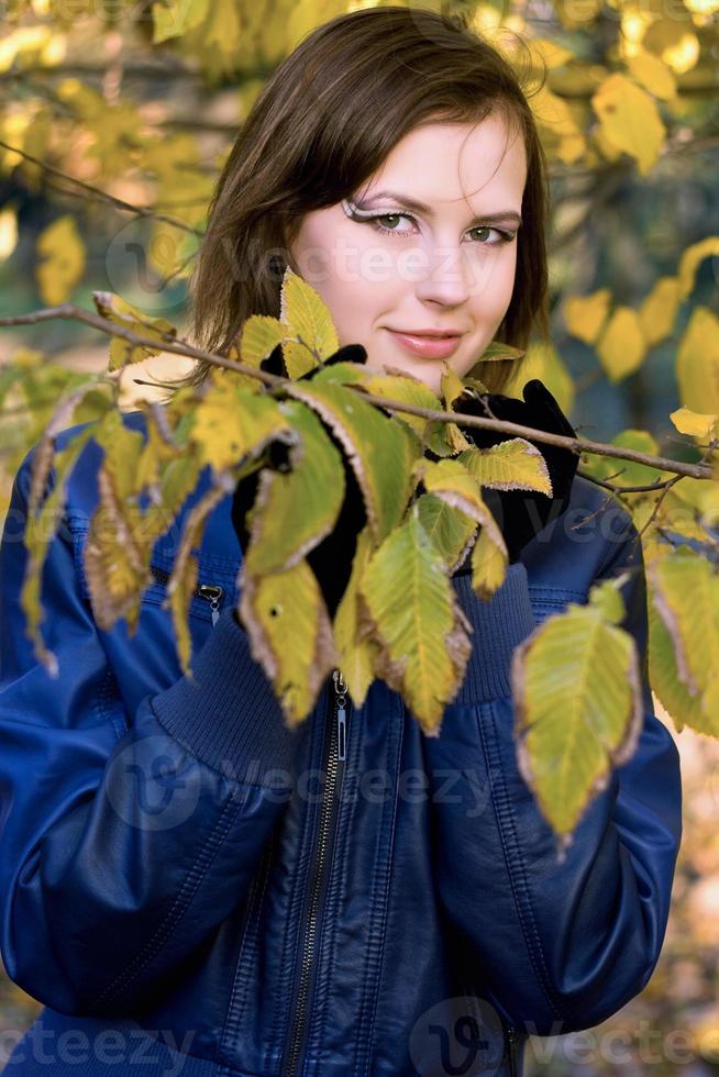 fille souriante parmi les feuilles d'automne photo