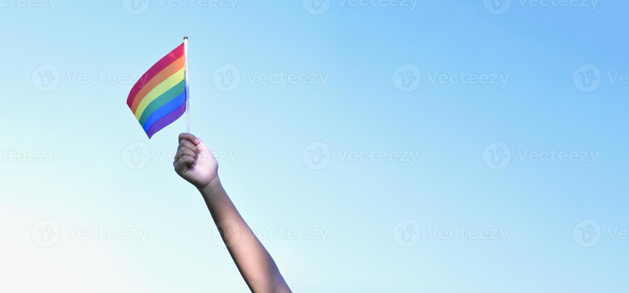 drapeau arc-en-ciel faisant contre le ciel bleu, espace de copie, mise au point douce, concept pour les célébrations lgbt du mois de la fierté, juin, dans le monde entier. photo