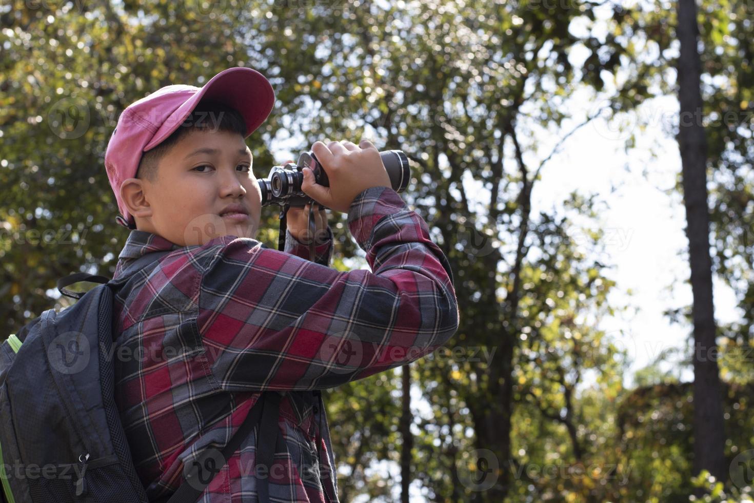 garçons asiatiques utilisant des jumelles pour observer les oiseaux sur les arbres et pêcher dans la rivière dans le parc national local pendant le camp d'été, idée pour apprendre les créatures et les animaux sauvages et les insectes en dehors de la salle de classe. photo