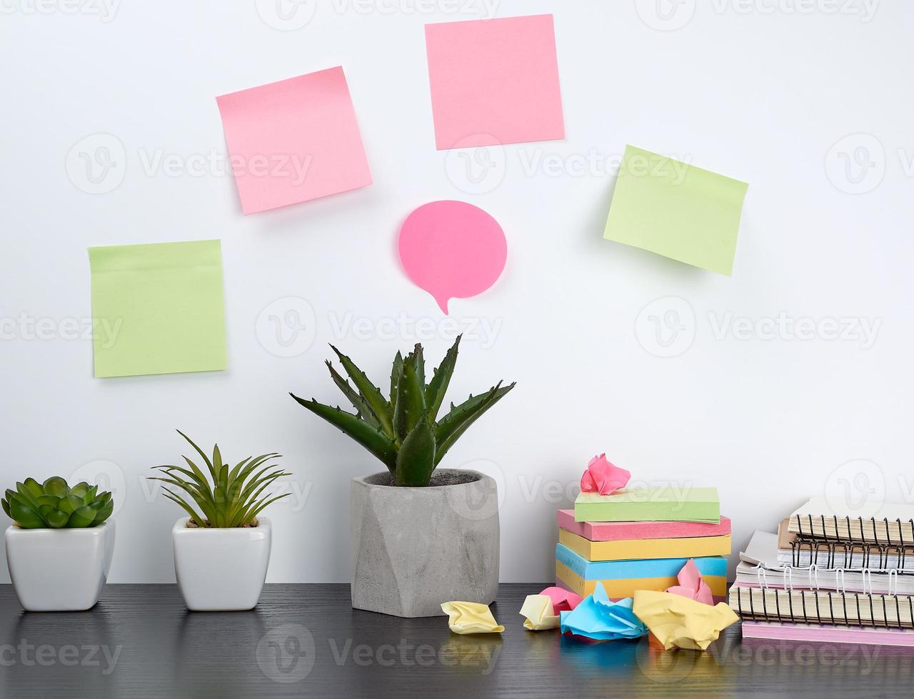 pile de cahiers à spirale et d'autocollants colorés, à côté d'un pot en céramique avec une fleur photo