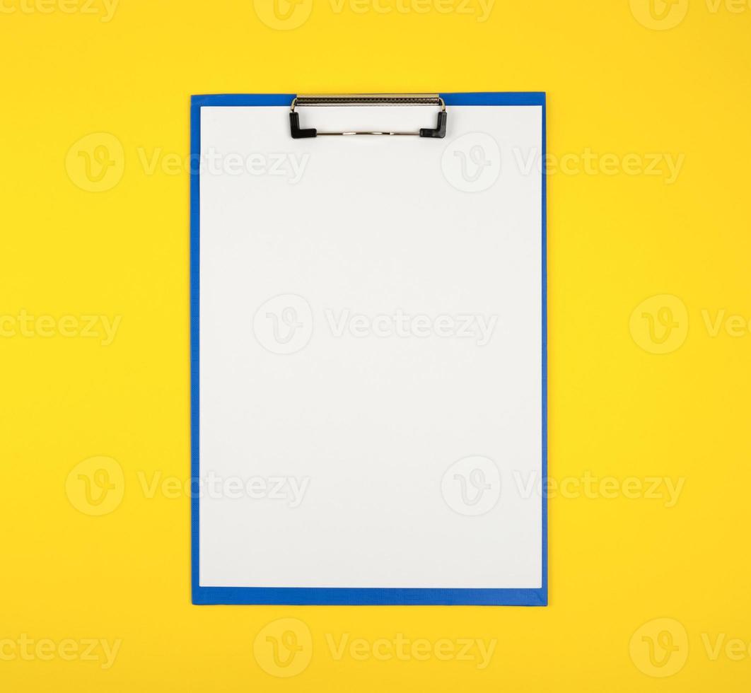 porte-papier bleu avec des feuilles blanches vierges sur fond jaune photo