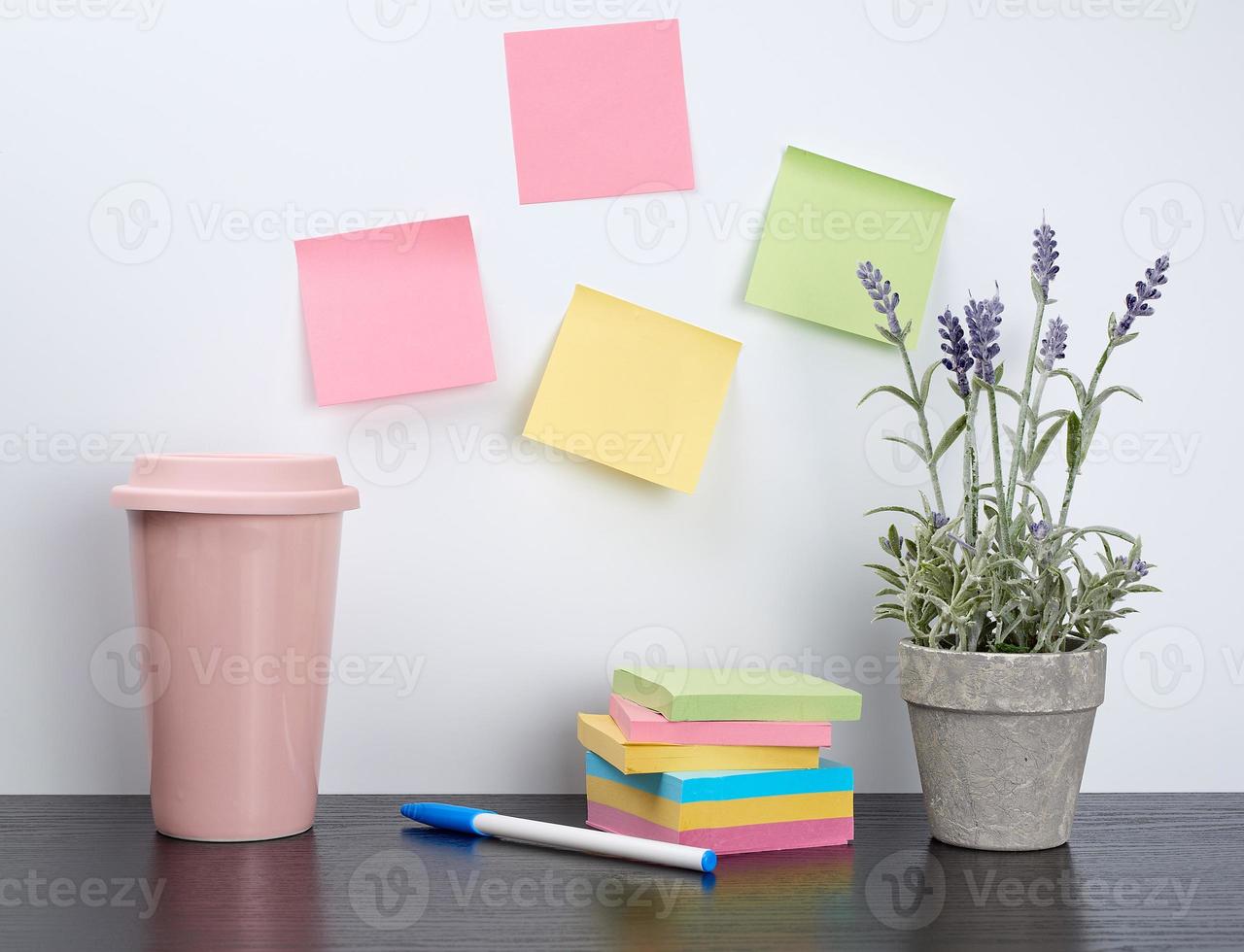 pile de cahiers à spirale et d'autocollants colorés, à côté d'un pot en céramique avec une fleur photo