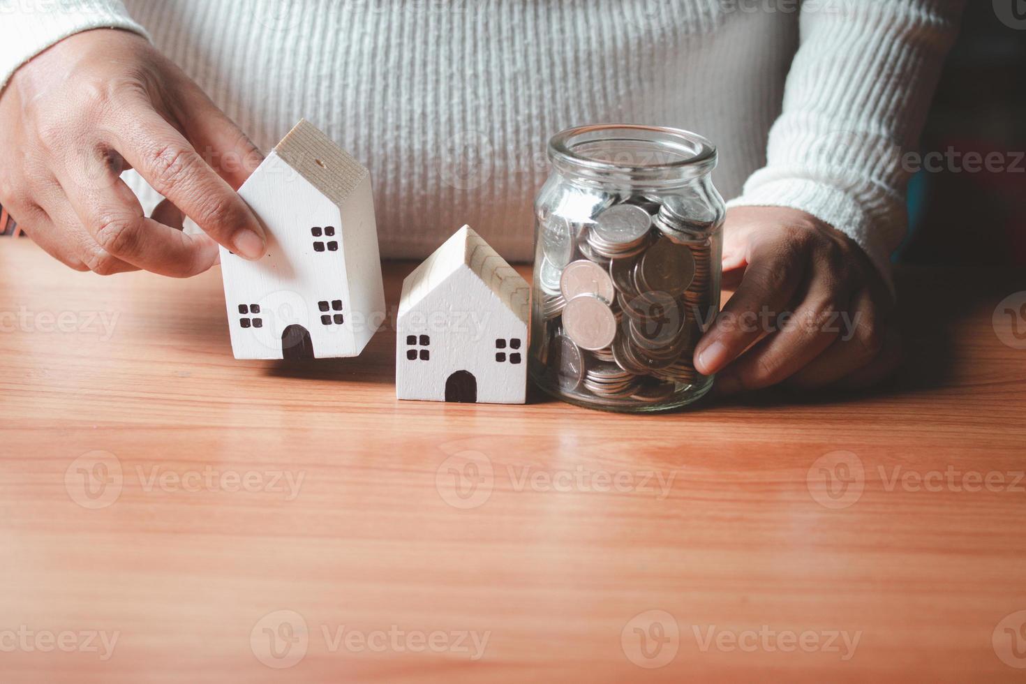 main avec caisse tenant maison et pot d'argent.pour acheter concept de maison .pour l'avenir. photo