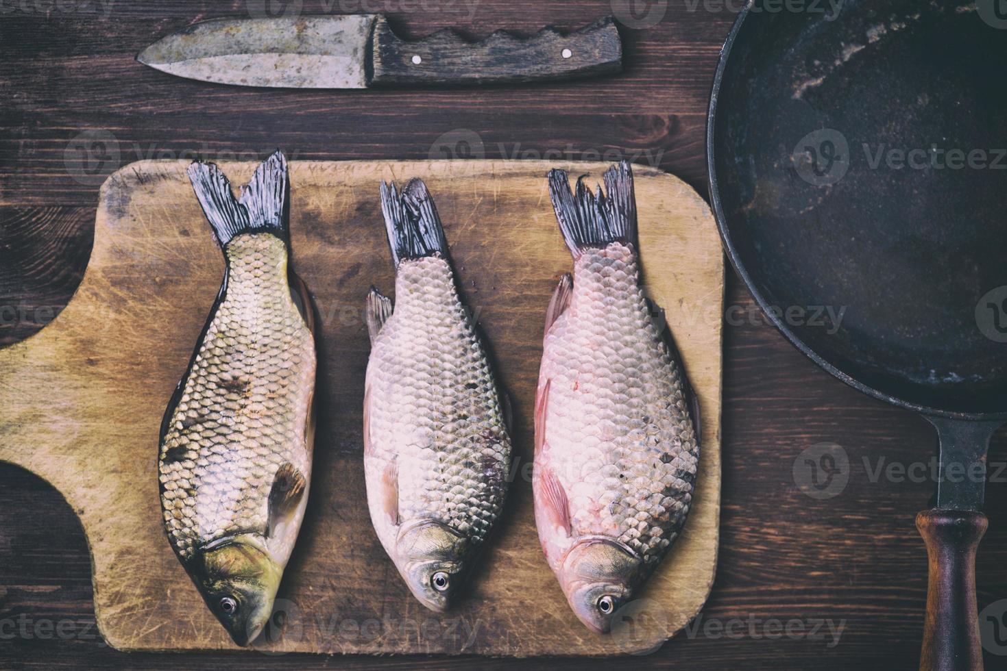 poisson carpe sur une planche à découper de cuisine photo