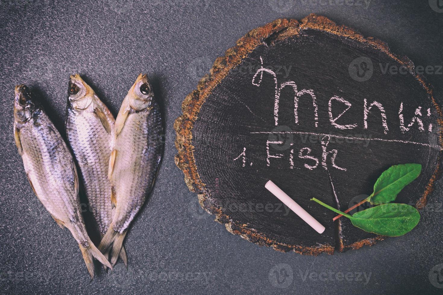 trois poissons séchés sur une surface noire photo