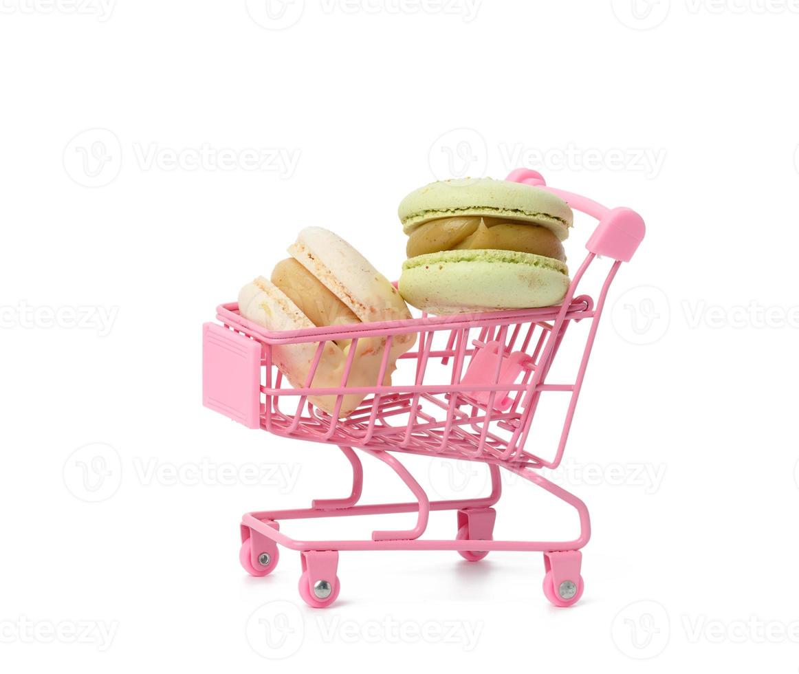 Macarons au four sur chariot métal rose isolé sur fond blanc photo