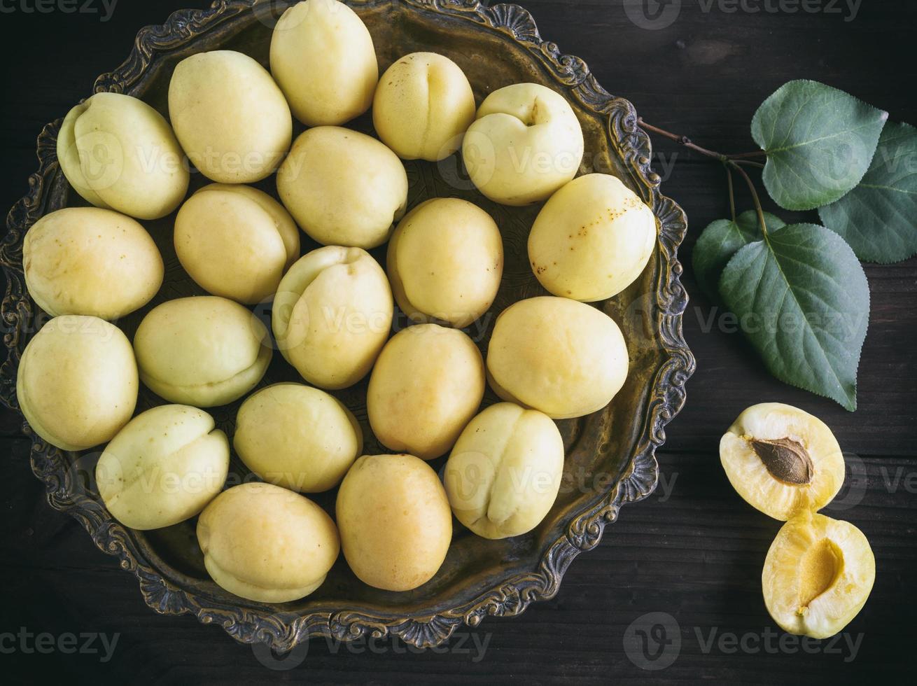 abricots mûrs frais dans une plaque de cuivre ronde photo