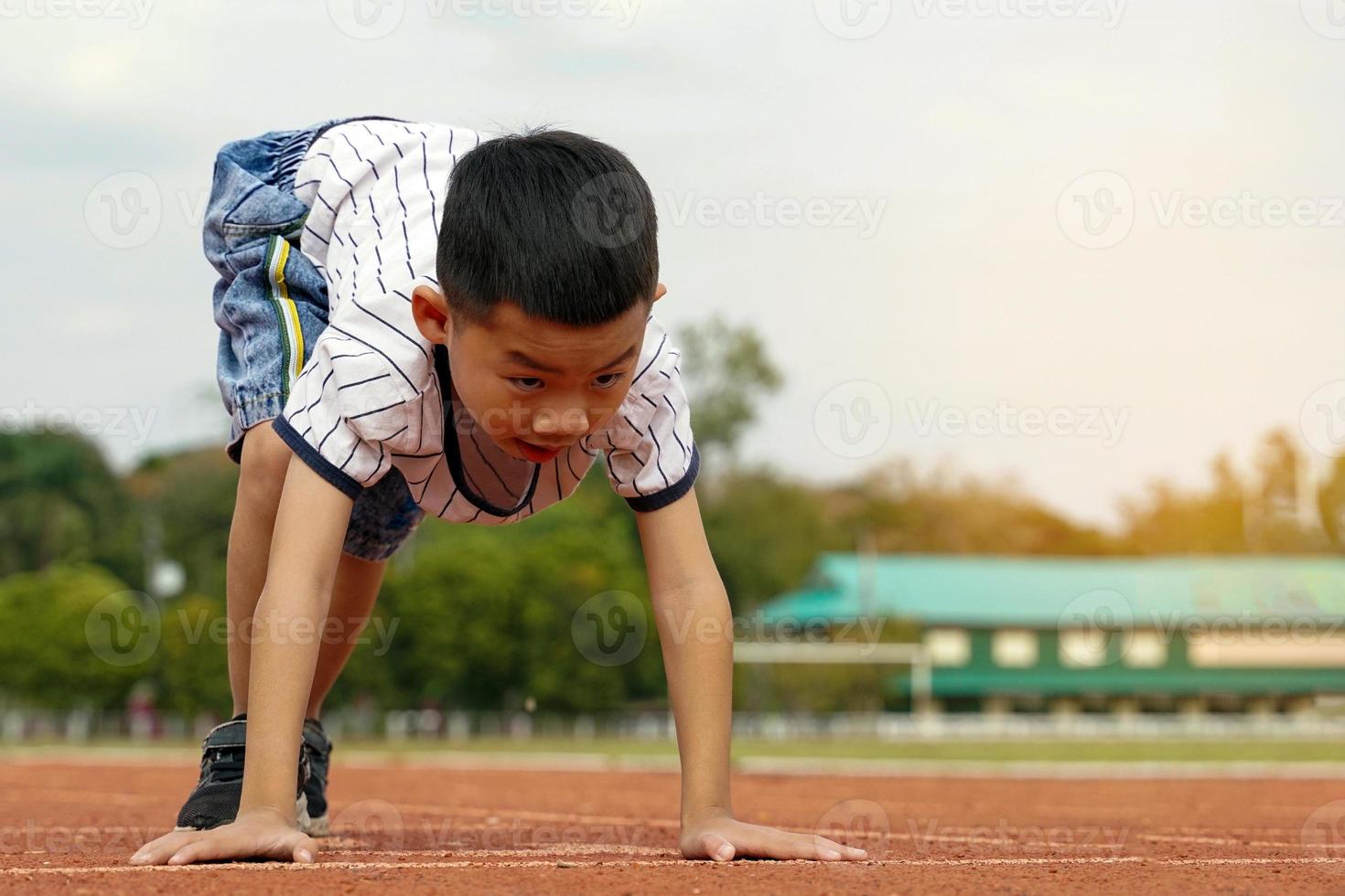 les garçons asiatiques ont commencé à courir sur la piste pour le concept de jeu en plein air, d'activités de plein air, d'activités de loisirs, d'exercice. mise au point douce et sélective. photo