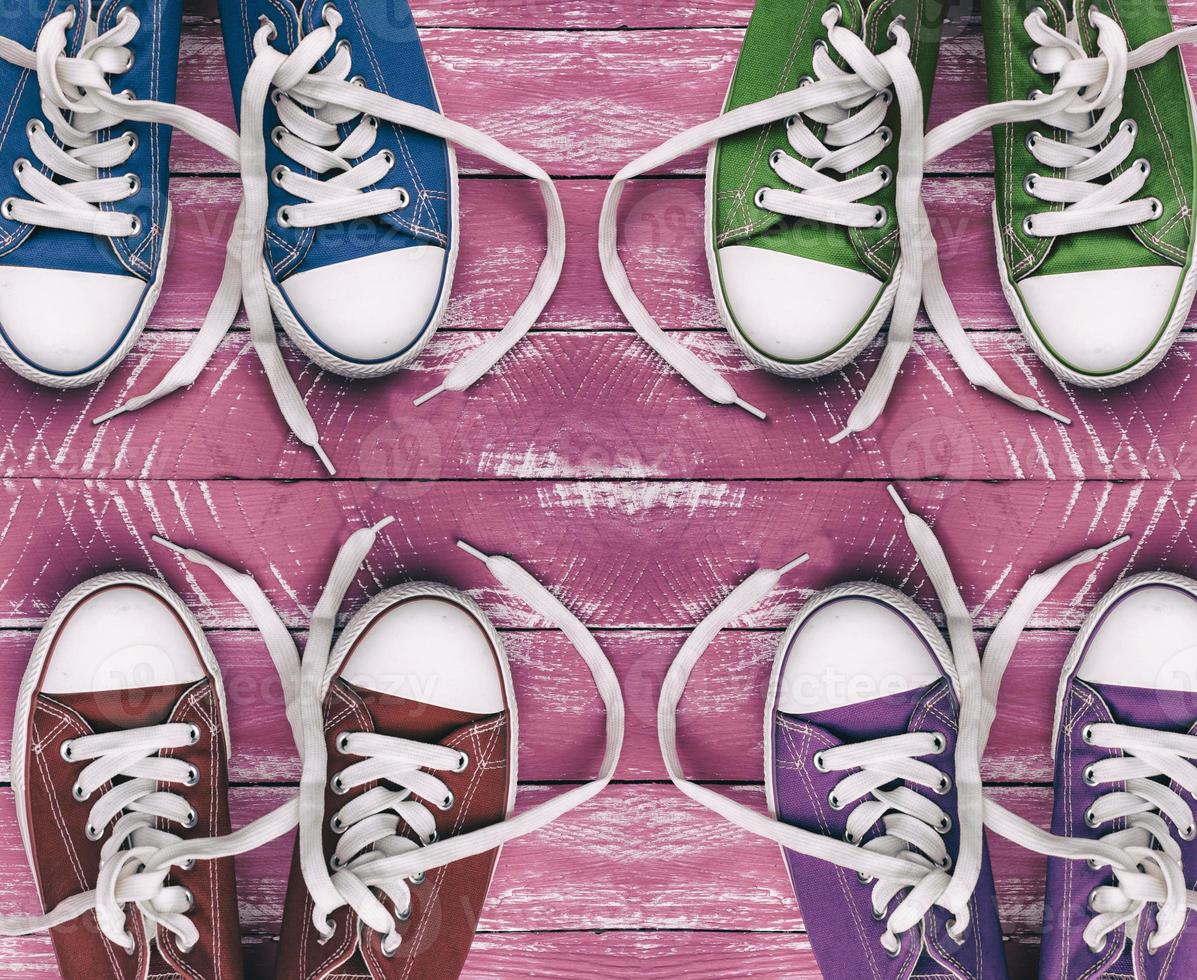 baskets colorées pour les jeunes sur une surface en bois rose ancienne, vue de dessus photo