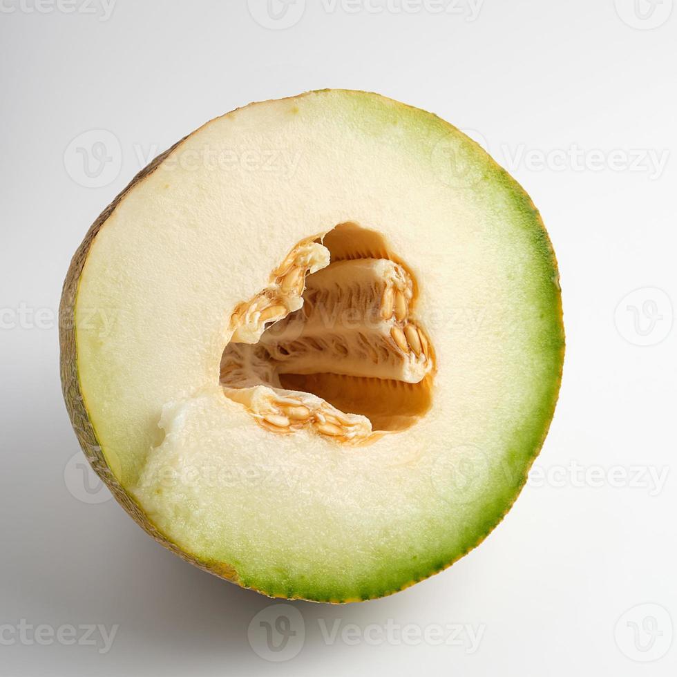 la moitié du melon jaune mûr avec des graines sur fond blanc photo