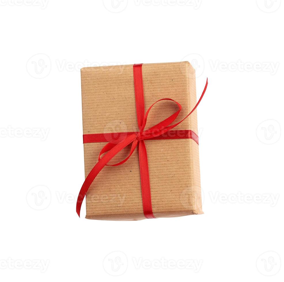 boîte rectangulaire enveloppée de papier brun et nouée d'un nœud rouge, photo