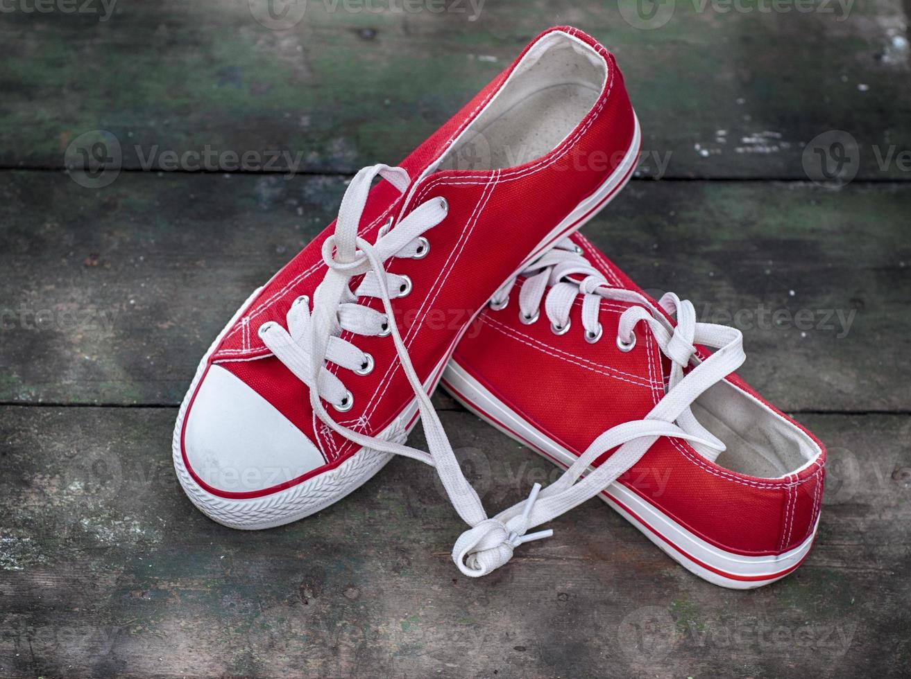 paire de jeunes baskets rouges sur une vieille surface en bois photo