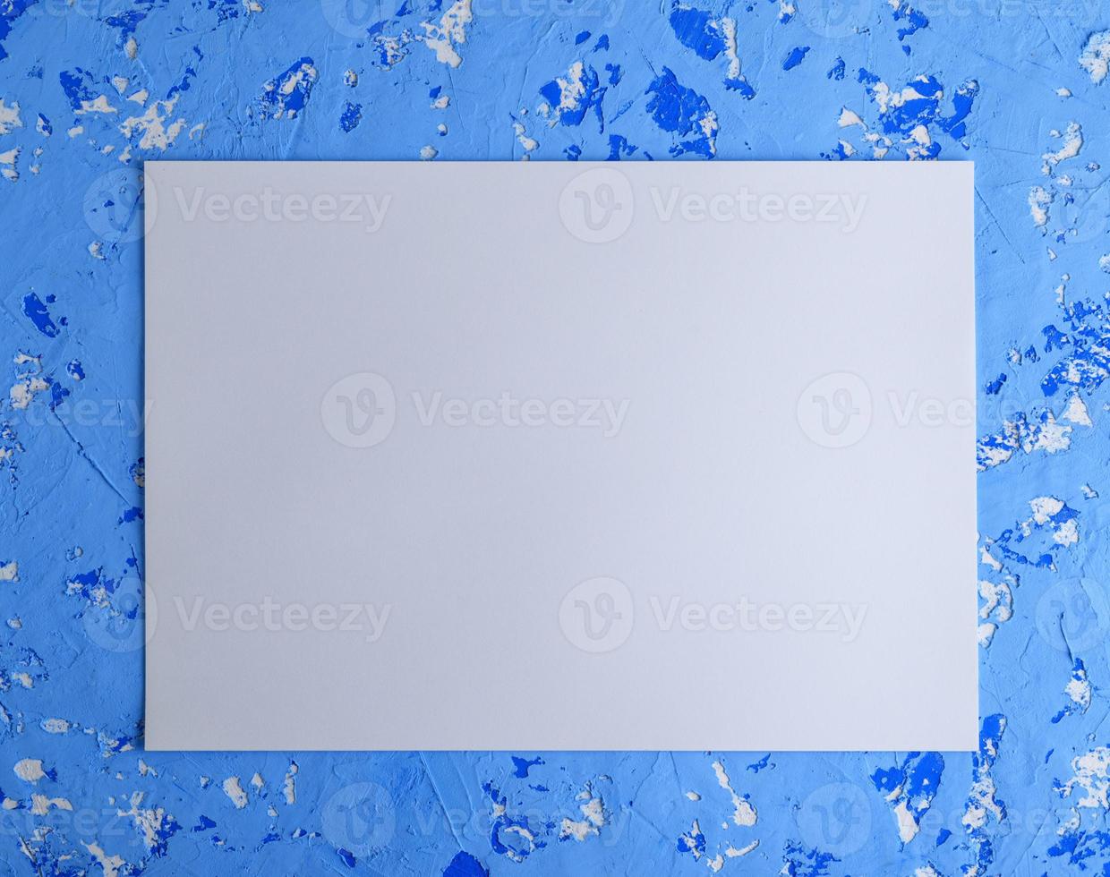 grande feuille blanche vide sur un mur de ciment bleu photo