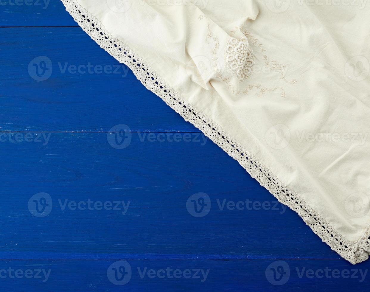 serviette textile de cuisine blanche pliée sur une table en bois bleue photo