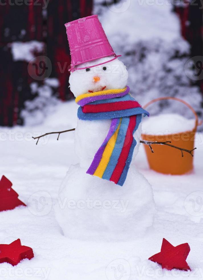 bonhomme de neige avec un seau sur la tête sur la neige blanche photo