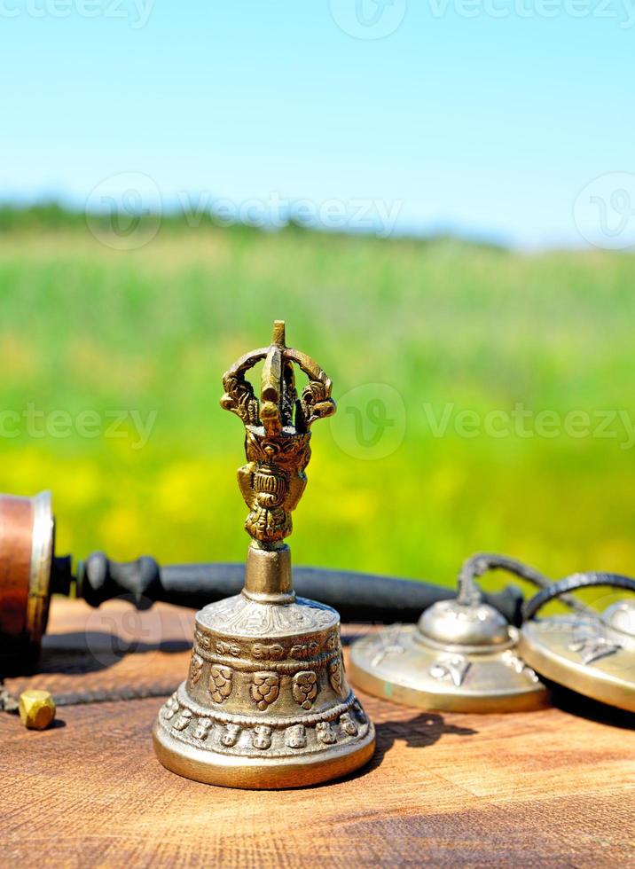 Cloche en cuivre avec objets religieux tibétains photo