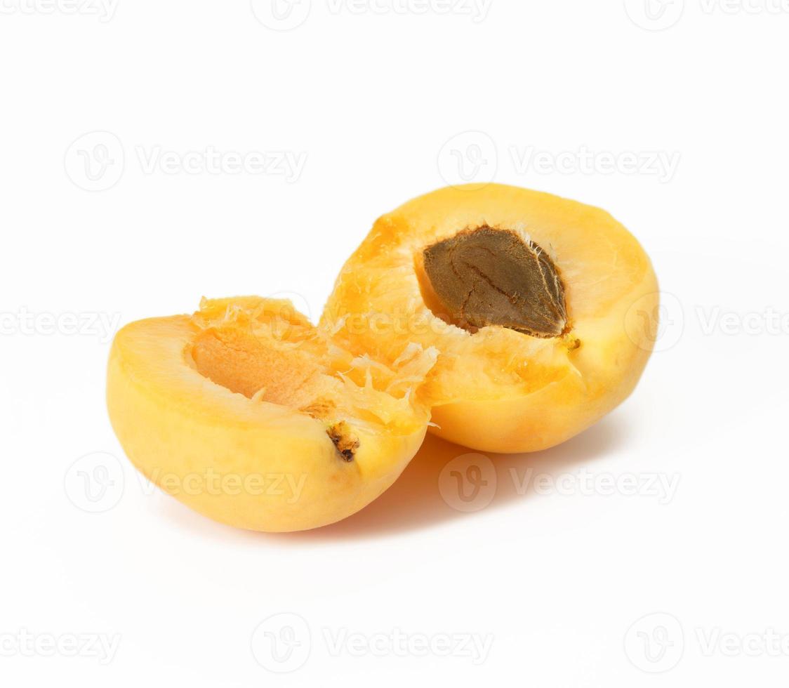 Abricot jaune mûr cassé en deux sur fond blanc photo