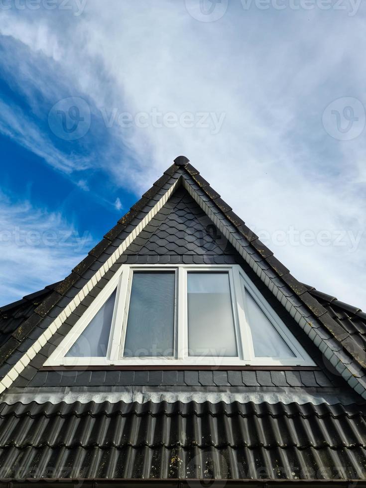 fenêtre de toit ouverte de style velux avec tuiles noires. photo