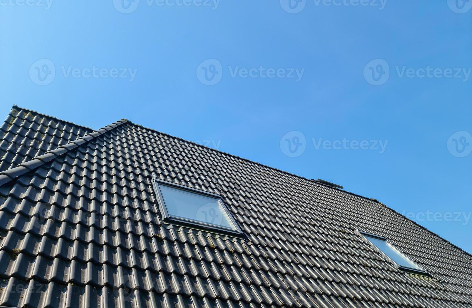 fenêtre de toit ouverte de style velux avec tuiles noires. photo