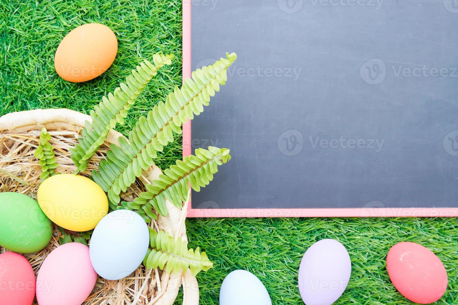 gros plan des oeufs de pâques sur l'herbe et la maquette du tableau noir photo