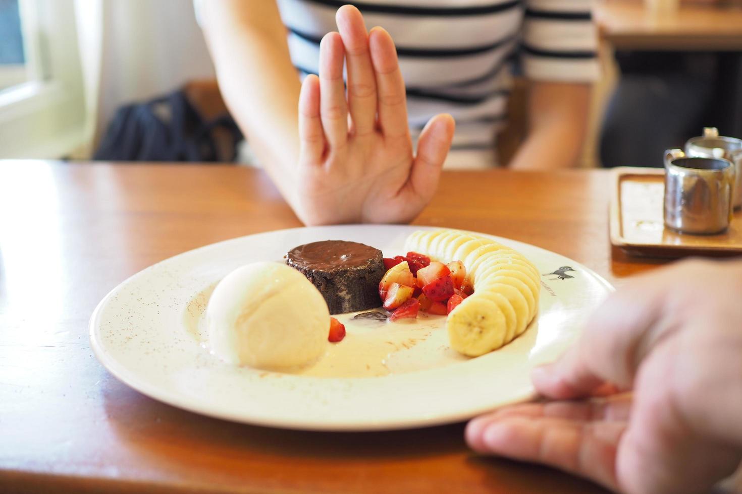 mains d'homme envoyant du bingsu à une femme. mais les femmes poussent leurs mains. elle a nié manger toutes sortes de sucreries. évitez le sucre et les desserts pour un bon concept de santé. photo