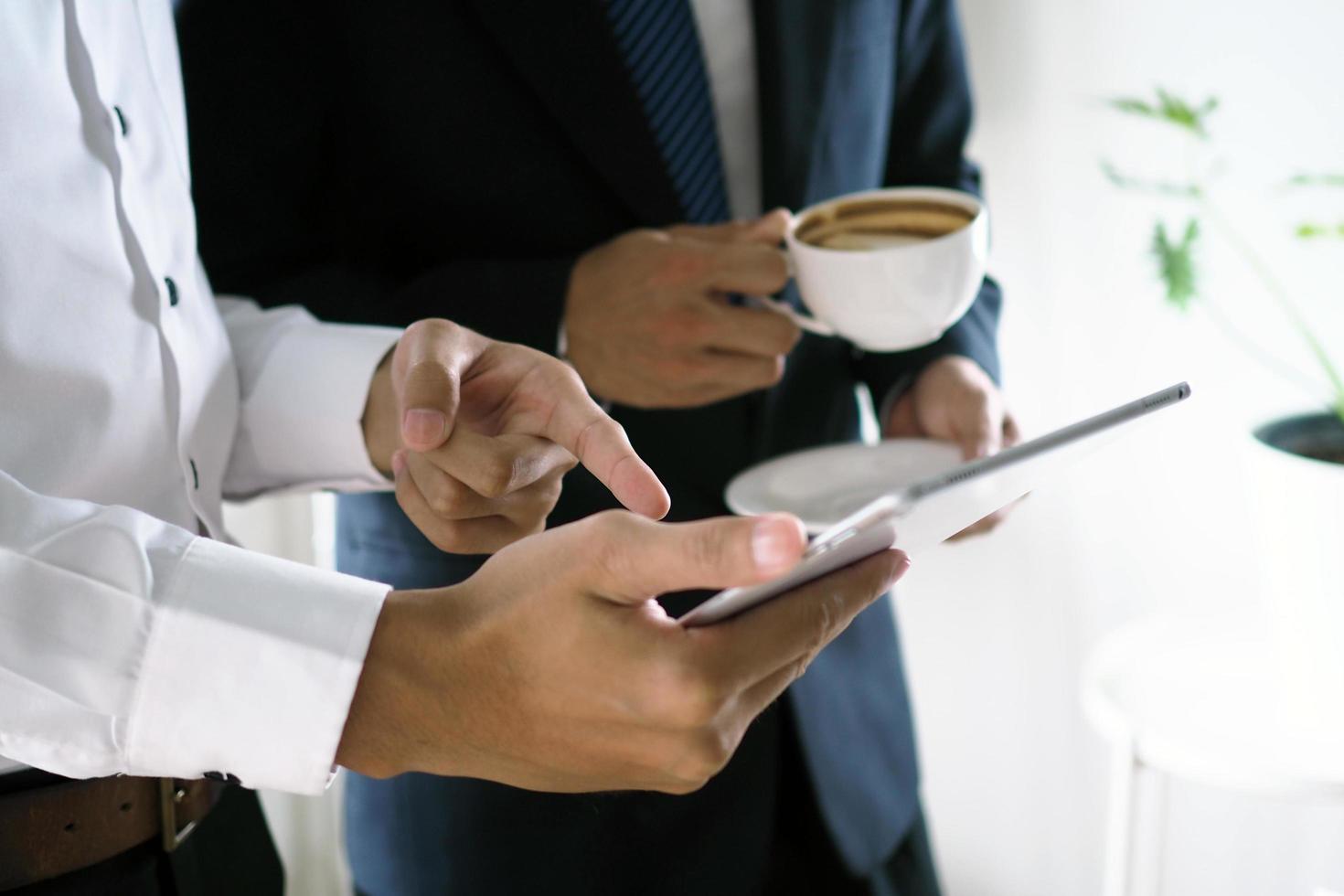 des hommes d'affaires présentent leur travail aux dirigeants via des tablettes tactiles. avec des informations en ligne, pratique pour rechercher photo