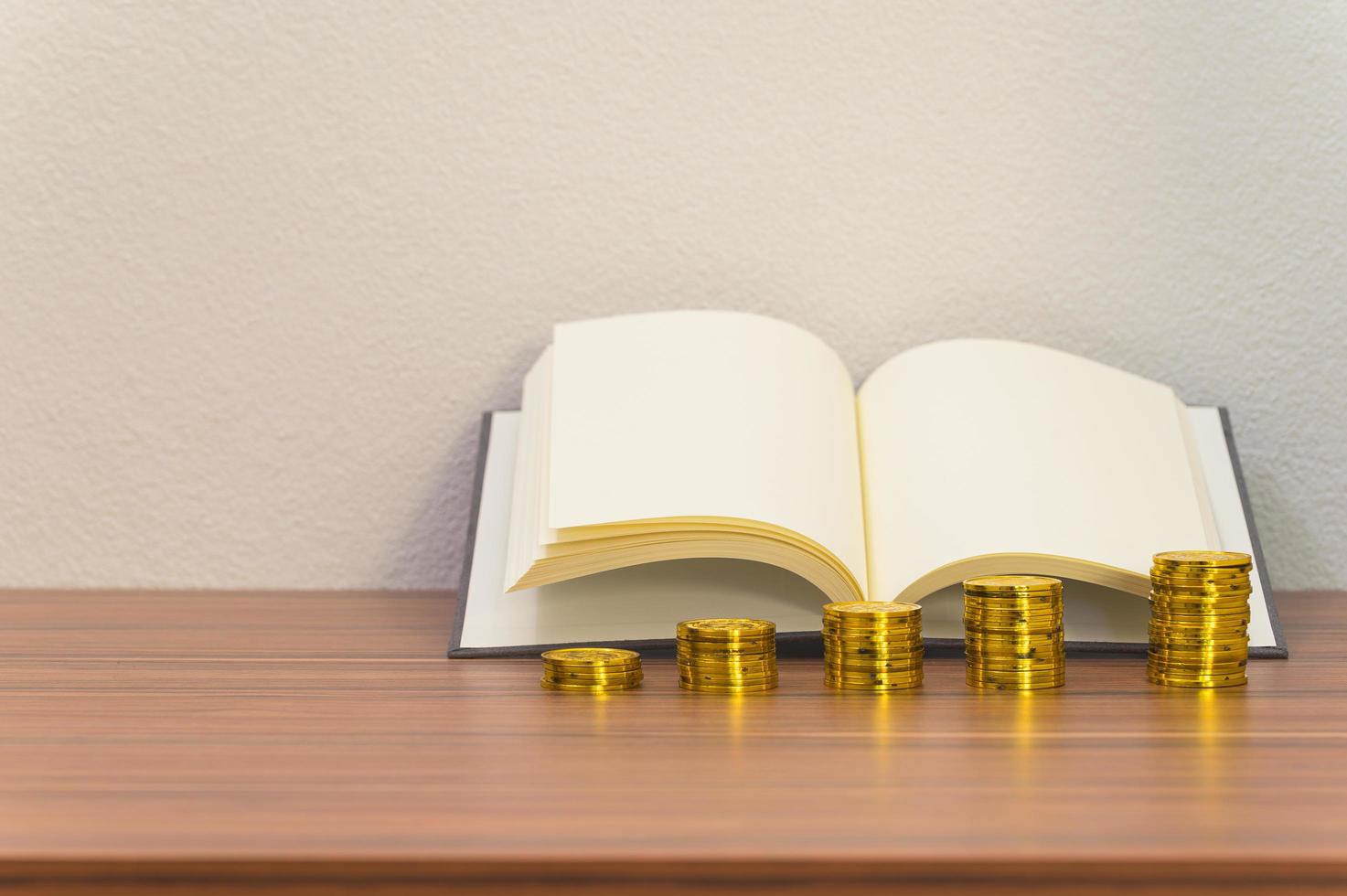 livres et piles de pièces sur le bureau photo