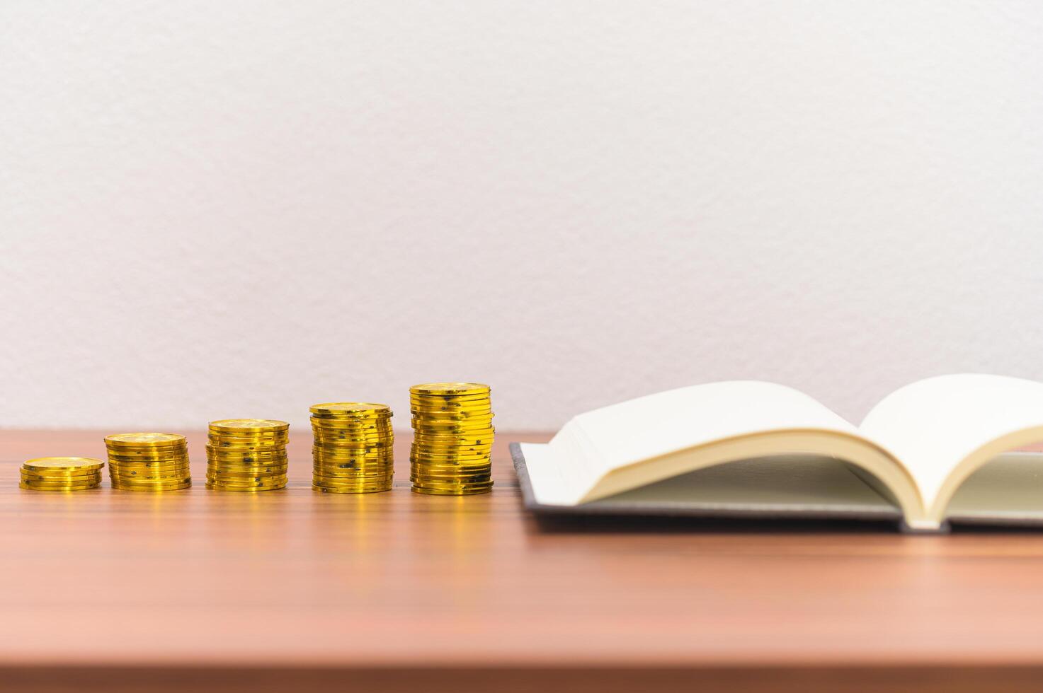 livres et piles de pièces sur le bureau photo