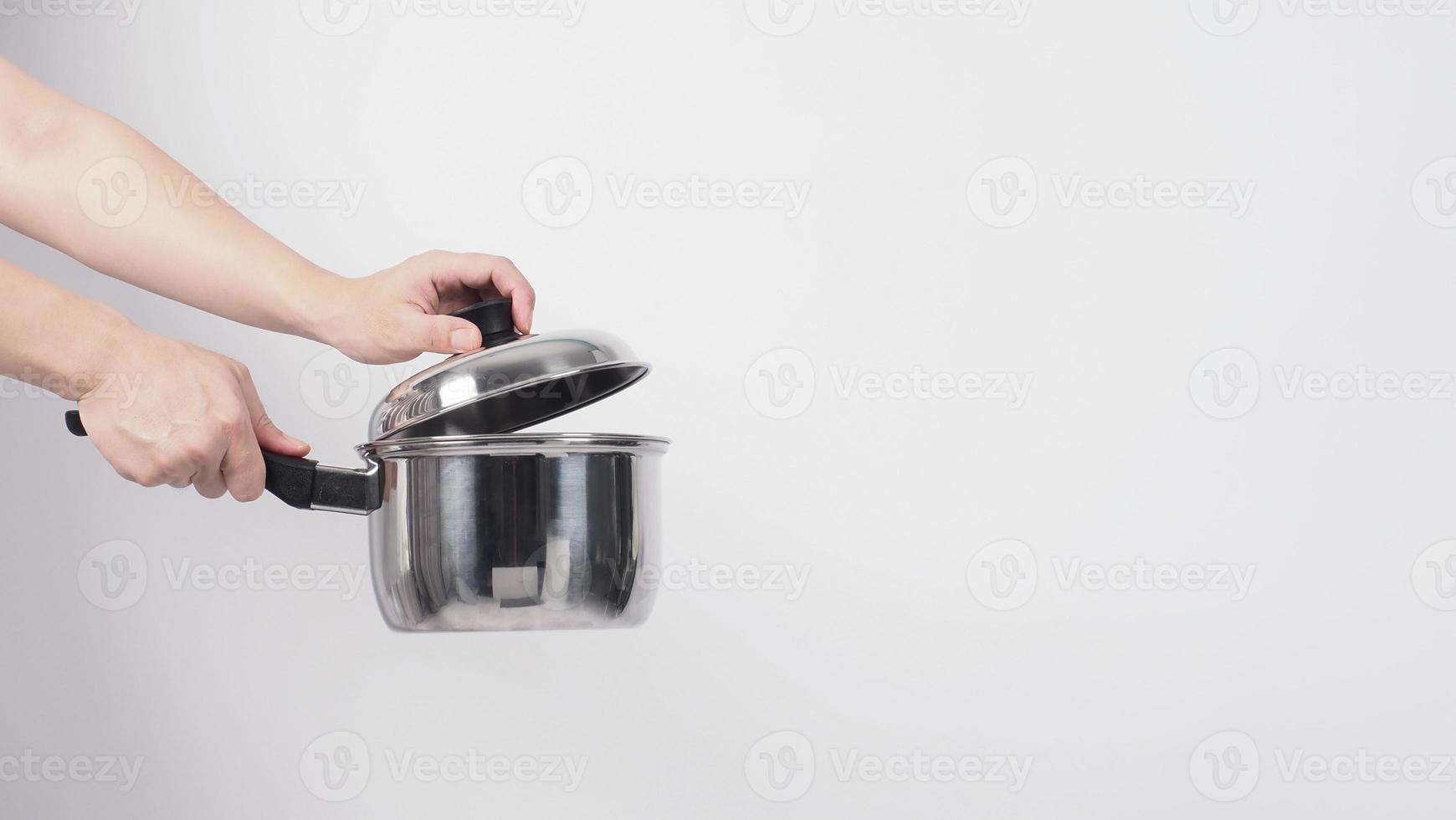 main d'homme de nettoyage de pot sur fond blanc nettoyant le pot antiadhésif avec une éponge à vaisselle pratique de couleur jaune sur le côté doux et verte sur le côté dur pour l'hygiène après la cuisson. marmite électrique photo