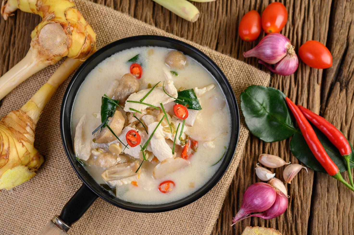 soupe tom kha kai avec feuilles de lime kaffir, citronnelle, oignon rouge, galanga et piment photo