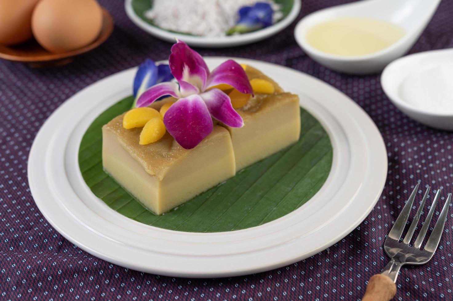 crème anglaise sur feuille de bananier avec fleurs de pois et orchidées photo