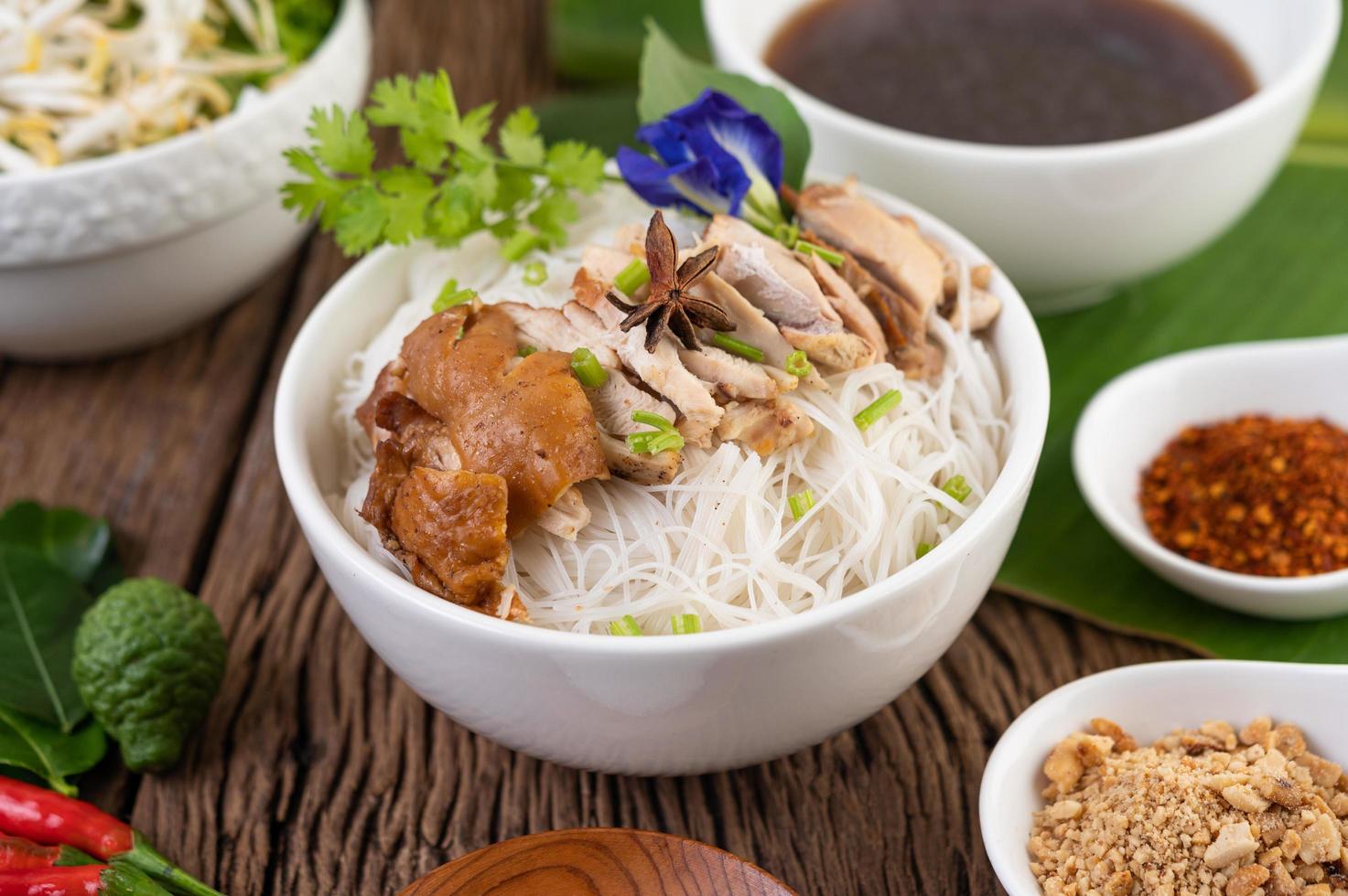 Nouilles au poulet dans un bol avec accompagnements thaïlandais photo