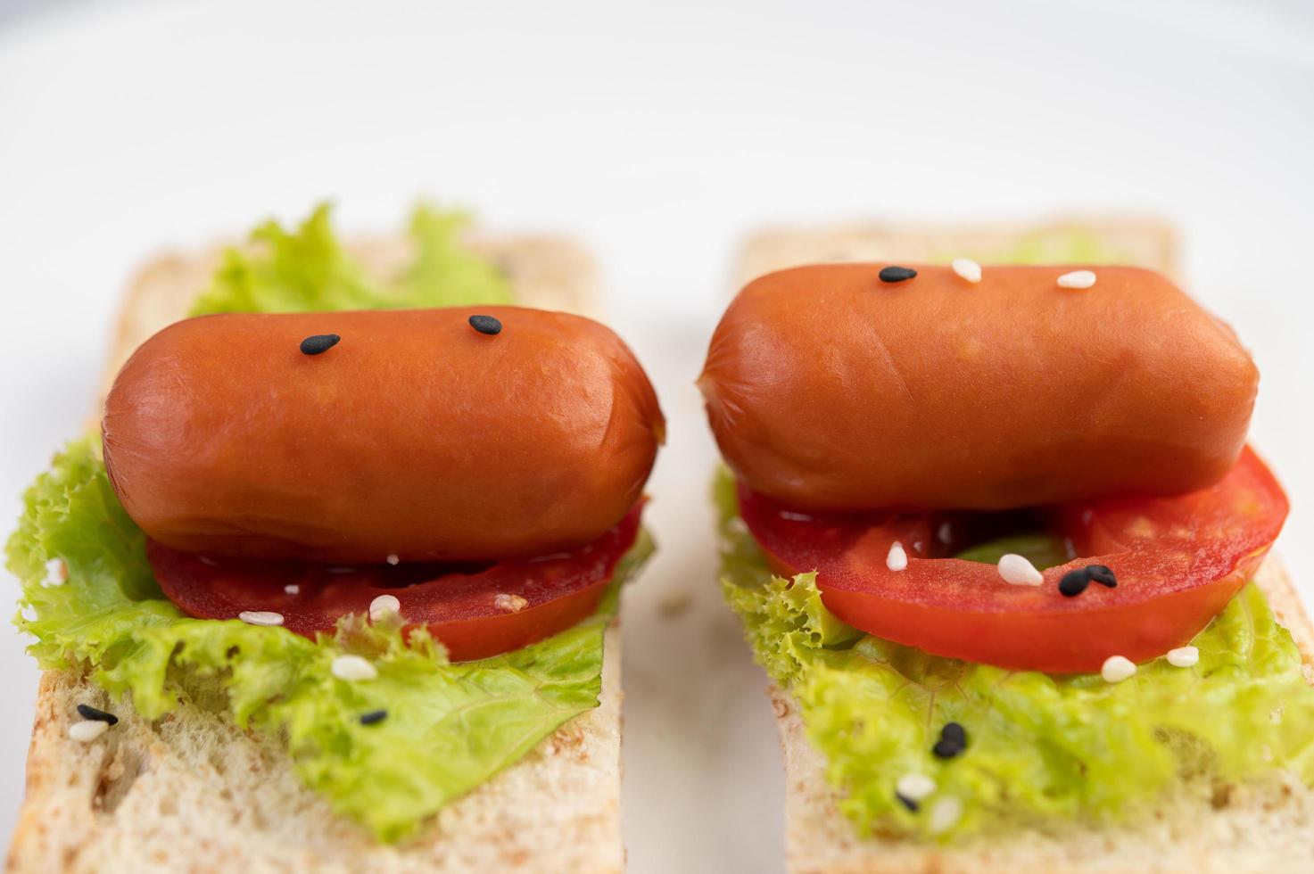 saucisse aux tomates et salade sur pain photo