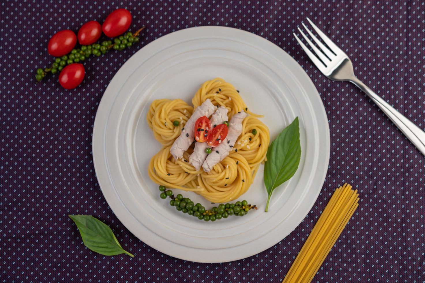 spaghetti et porc plaqués disposés sur une assiette blanche photo