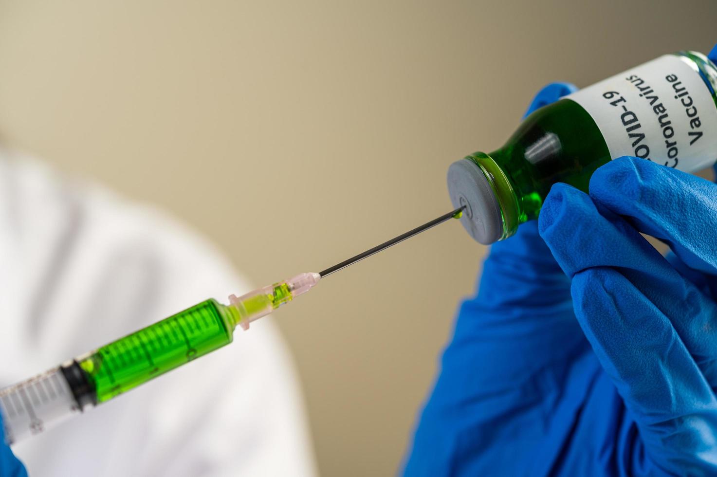 des scientifiques portant des masques et des gants tenant une seringue avec un vaccin covid-19 photo