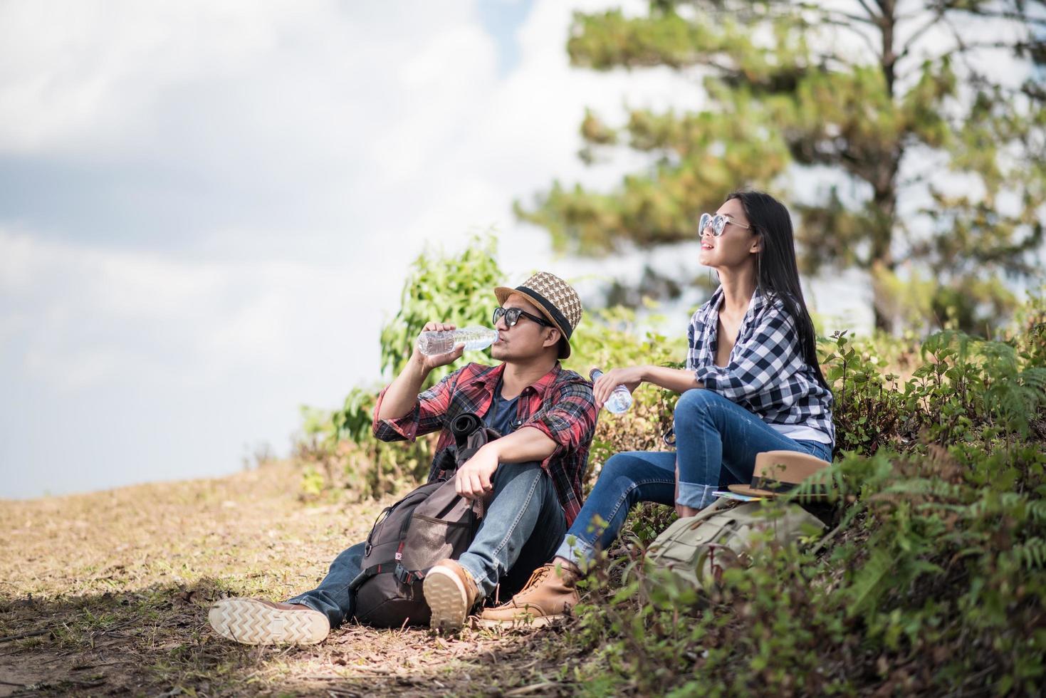 jeune couple regardant la carte lors d'une randonnée dans la forêt photo