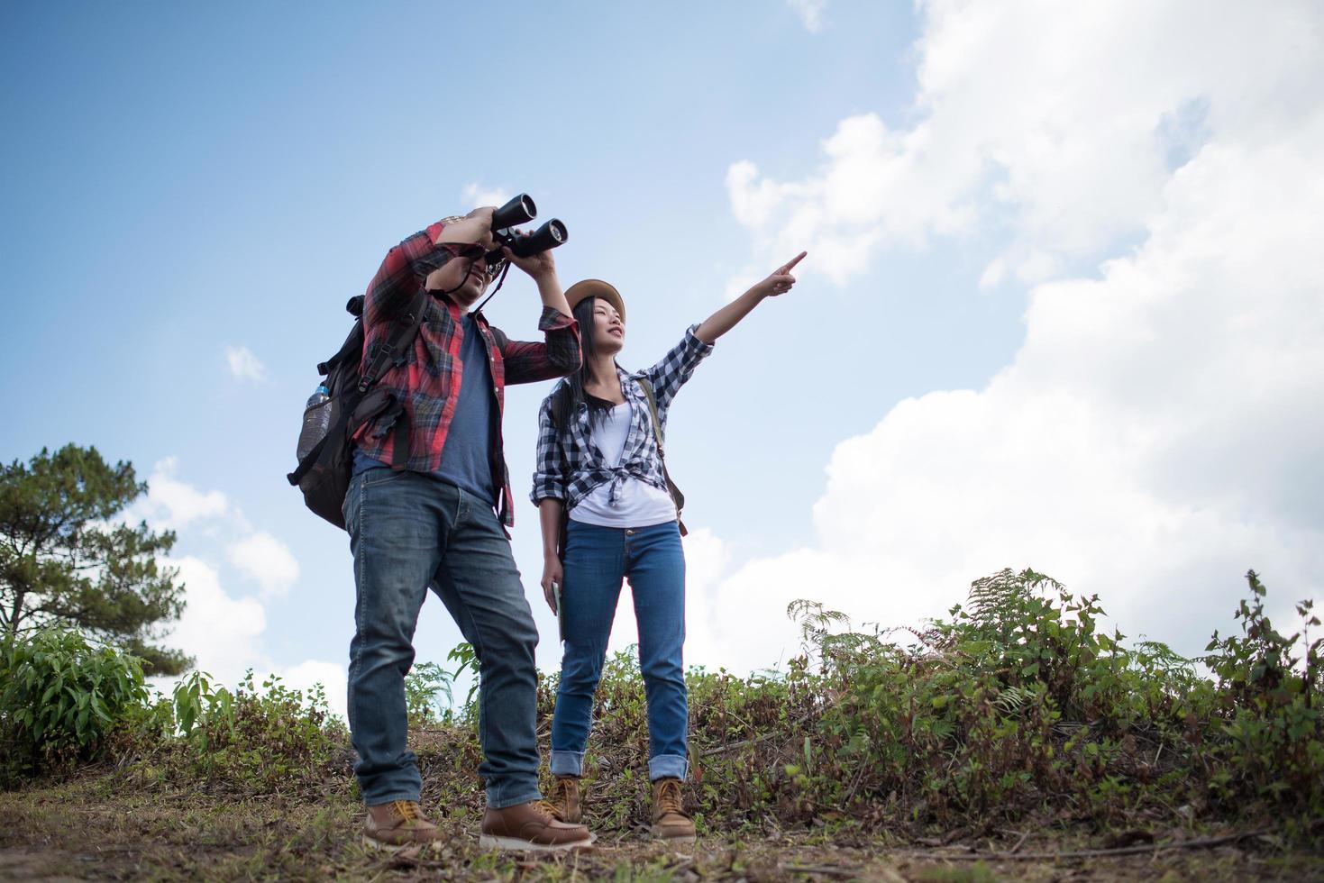 jeune couple marchant avec des sacs à dos en forêt photo