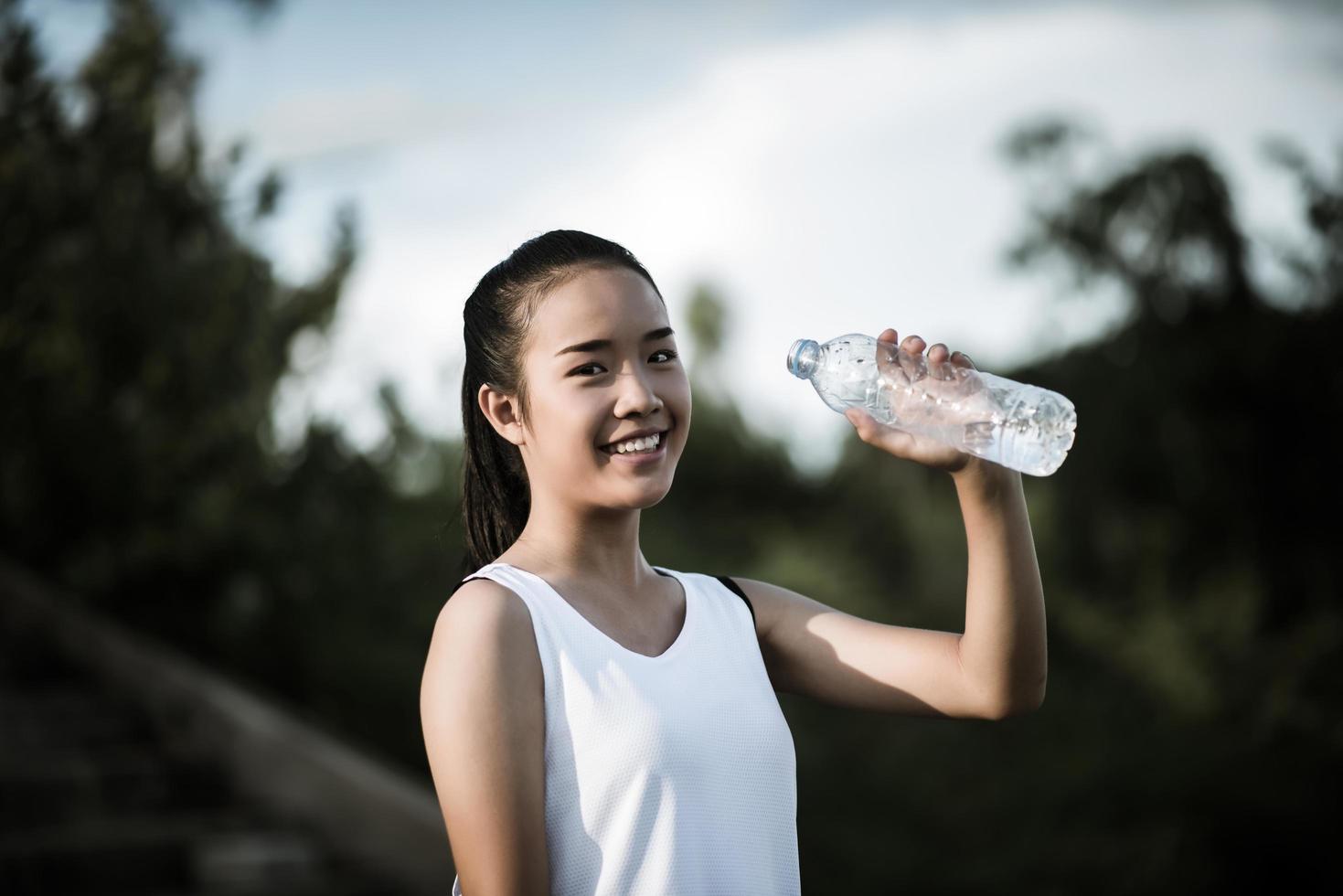 Young fitness teen holding bouteille d'eau après l'exécution de l'exercice photo