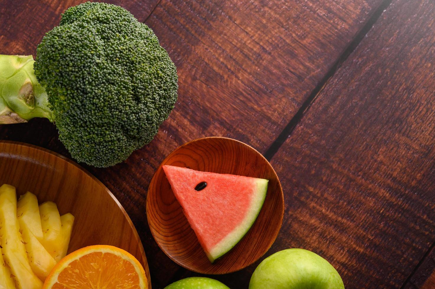 couper des pastèques, des oranges et des ananas avec des pommes et du brocoli photo